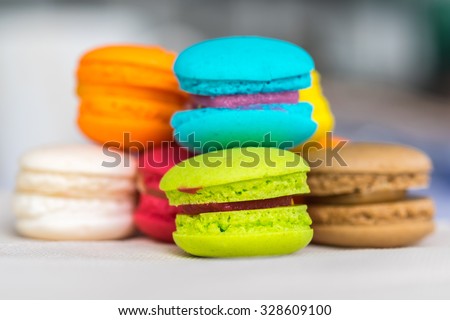 Colorful macarons on earth tone paper against blur outdoor background , Shallow depth of field with selective focus on yellow macaron.