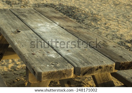 Weathered old picnic table sitting on the beach