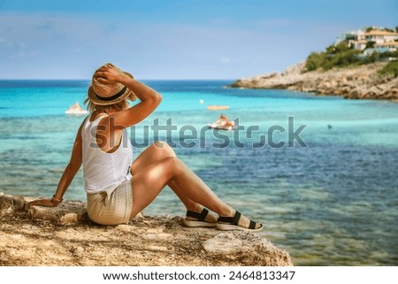 Similar – Image, Stock Photo Tourist with straw hat in rear view photographs a sailing ship in Brittany at the sea between rocks