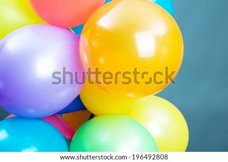 Various orange, purple, blue and green balloons tied together.