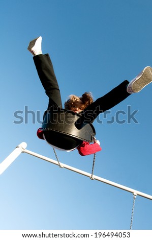A girl swinging on a swing high in the air.