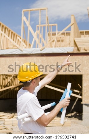 A construction worker pointing towards the structure being built.