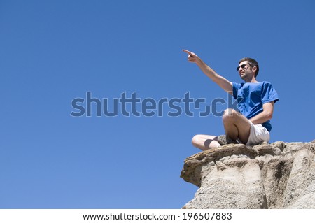 A man sitting on the edge of a cliff.