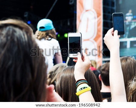 People recording a performance on their cell phones.
