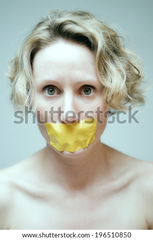 A woman with a piece of yellow tape over her mouth.