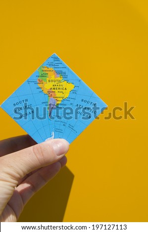 A person holding a folded map of the Earth.