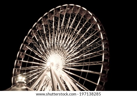 A close-up of a ferris wheel lit up by lights.