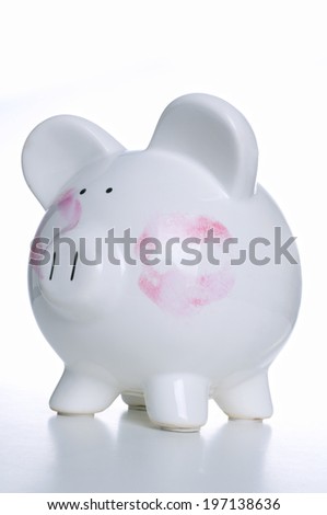A white ceramic piggy bank with a large lipstick print on each cheek.