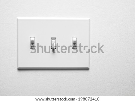 Two switches turned on and one turned off on a panel.