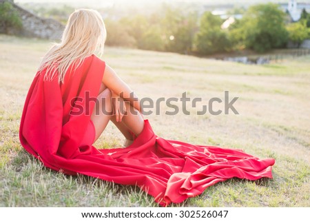 Resting superhero, blonde wonderwoman posing outdoor