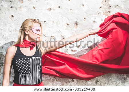 Young woman posing as superhero or superwoman