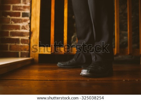 Formal Attire Black Pants and Shoes Standing on Rustic Hardwood and Brick