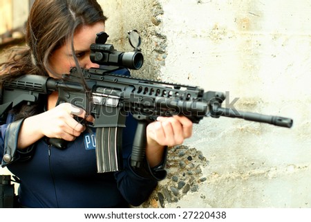 Sexy police officer aiming assault gun.