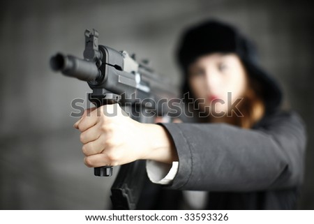 A young and stylish woman pointing an assault.