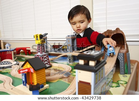 Young toddler playing with a wooden train set.