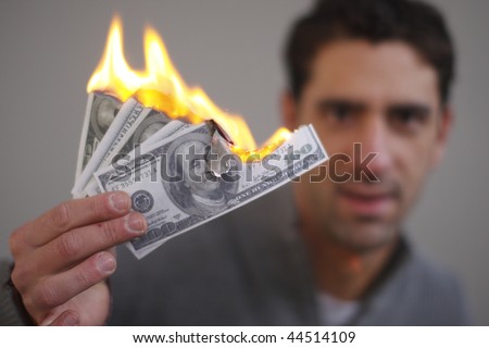 Young man burning cash.