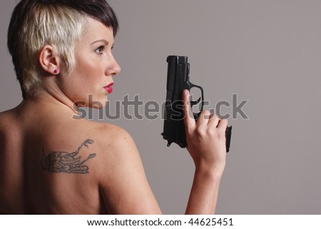 Young and sexy woman with a pistol.