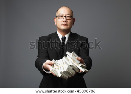 Businessman handing out bundles of cash.