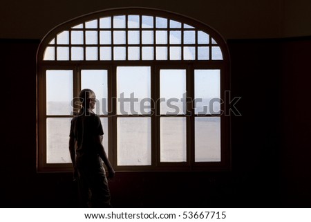 Man staring out of a window into the desert