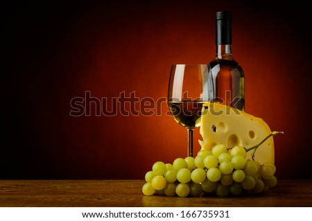 still life with glass and bottle of white wine, cheese and grapes
