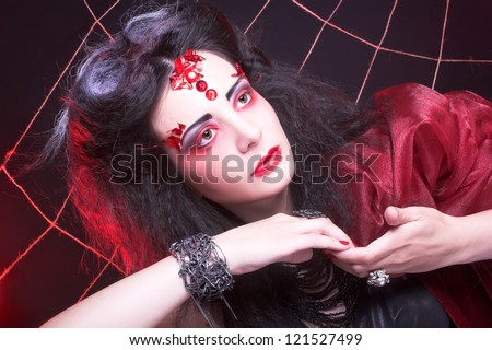 Black widow. Young woman in creative image.