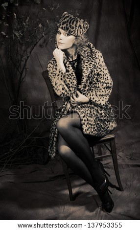Lady in retro style. Young curly woman in fur coat and hat.