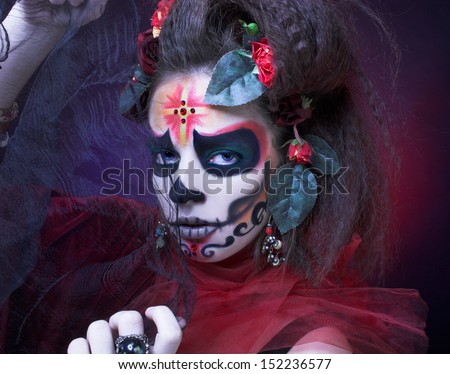 Santa Muerte. Young woman with creative visage and with roses in her hair.