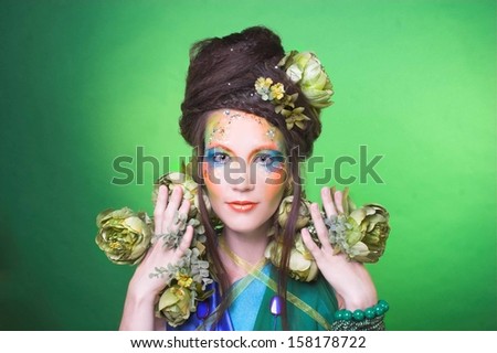 Summer fairy. Young woman with creative visage and with flowers.