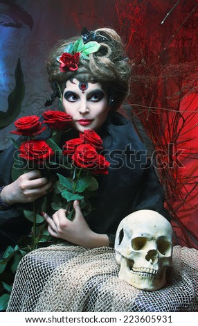 Halloween image. Young woman in dramatic artistic image with rose\'s and skull