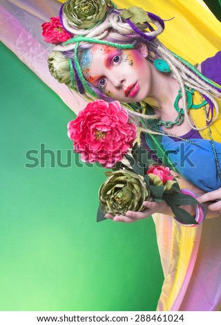 Summer fairy. Young woman in artistic image and with flowers in hair.