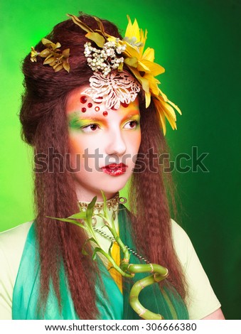 Fairy. Young woman in artistic image with flowers in her hair and with bamboo.