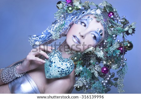 Silver valentine. Young woman in creative image posing with heart