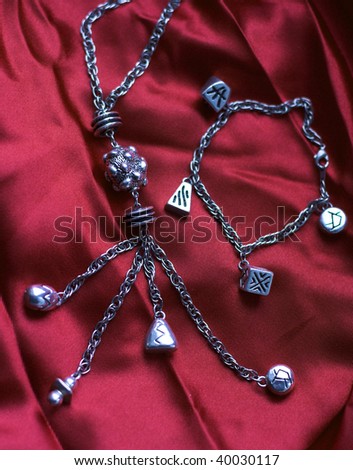 Silver necklace and  bracelet on the red silk