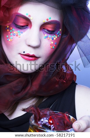 Young lady with bright make-up in doll-style witn glass box and beads in it