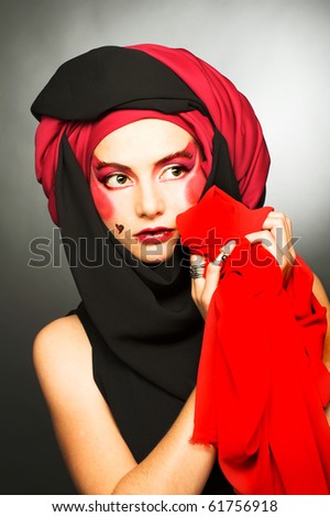 Young woman with creative make-up in black and red turban