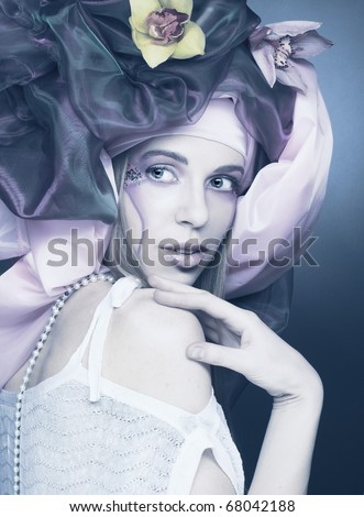 Romantic portrait of young lady with original make-up in cold tones