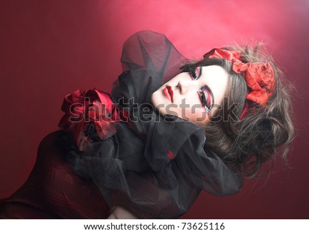 Queen of hearts. Creative lady in black and red colors and with bright make-up.