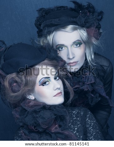 Two young ladies in vintage hats and corsets and with  artistic creative make-up.
