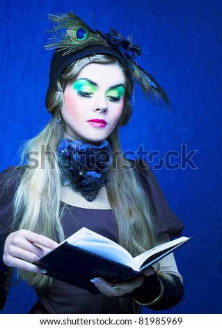 Portrait of young lady in creative image and with book in her hands.