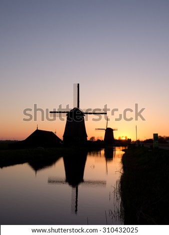 Two windmills reflected in the evening glow
