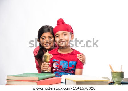 Indian sikh/Punjabi  boy and girl studying with books and laptop computer at study table Stock fotó © 