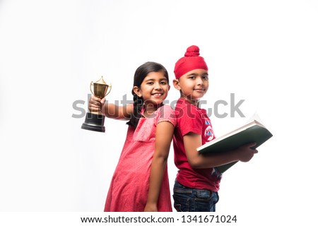 Indian  sikh / punjabi small girl and boy standing with a book and Victory Cup - education and success concept  Stock fotó © 