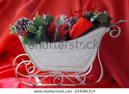 Christmas image of decorations piled in a decorative sleigh with copy space on the side of the sleigh