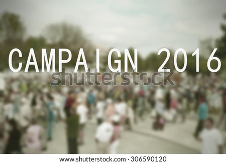Background blur of crowd at political rally in the United States holding signs and carrying US flags for upcoming election cycle in 2016 presidential campaigns. Vintage filter and message added