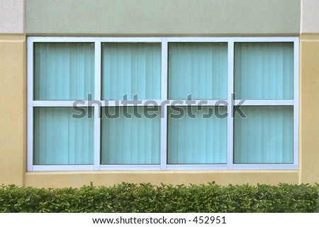 8 symmetrical tinted glass windows with hedge