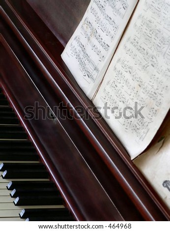 detail of vintage sheet music open on piano with a few keys showing