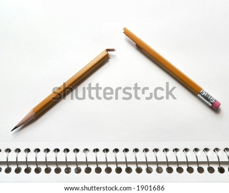 Single pencil broken in two on heavily textured white paper with wire spiral binding