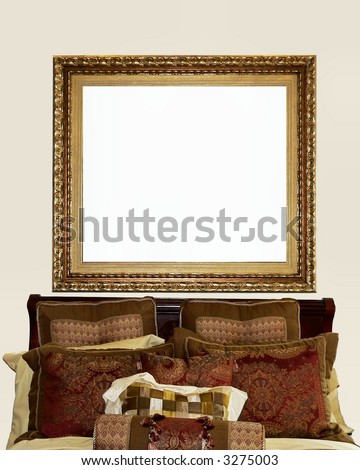 Place your own image or copy in the framed space hanging above a dressed bed.  The pillows are in rich tones of gold, burgundy, rust, green and cream colors.  The frame is ornate. Vertical orientation