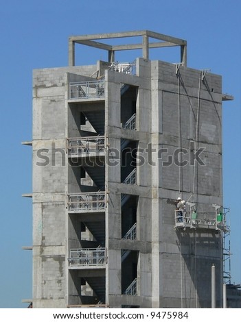 multi level new construction with workers on hanging platform
