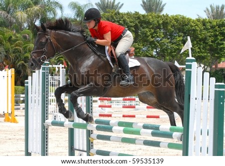 WELLINGTON, FLORIDA - AUG 21: An unidentified competitor clears a jump at the first Palm Beach County Horsemen\'s Association Show of the 2010-2011 season on August 21, 2010 in Wellington
